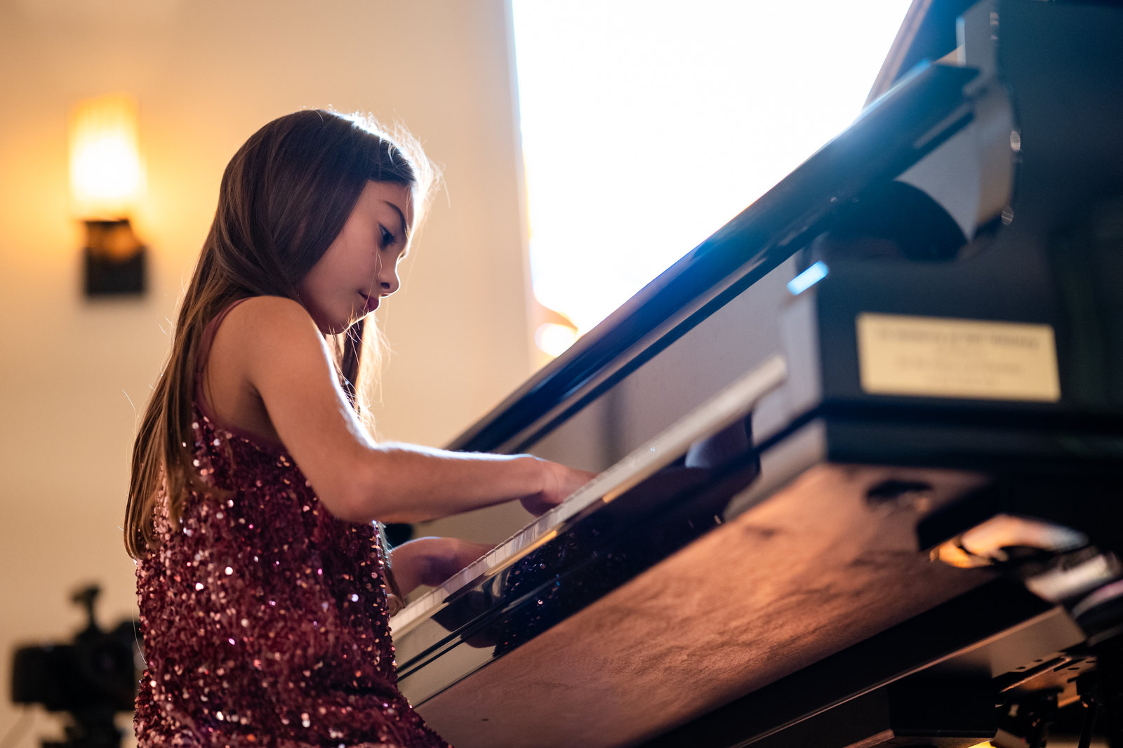 A young pianist at a grand piano, photographed by Mathew Harwich